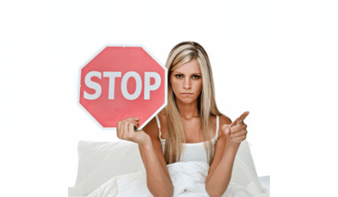 woman in bed stop sign